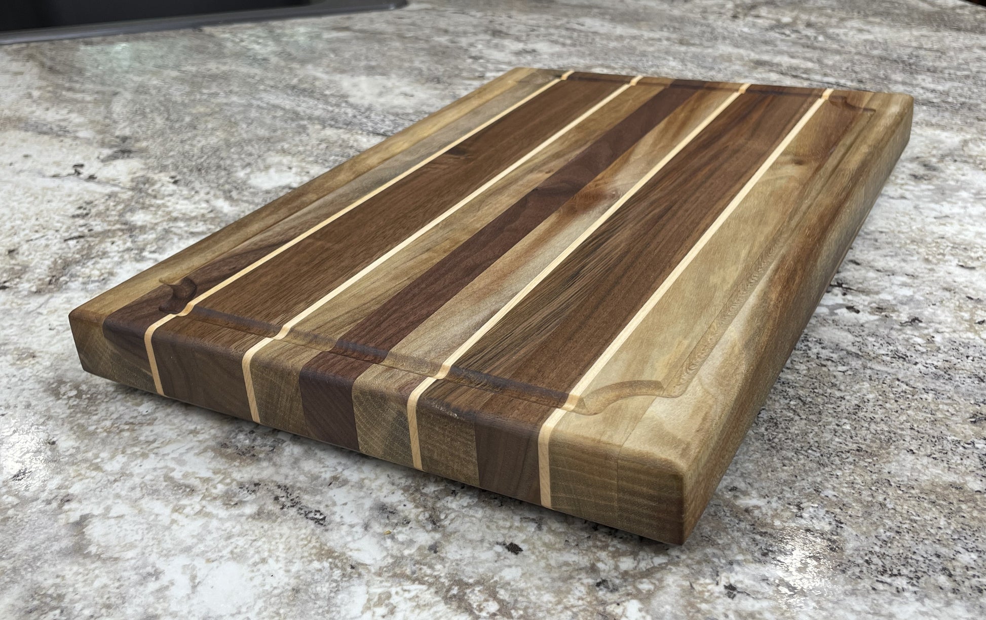 Wooden cutting board with a striped pattern on a concrete surface